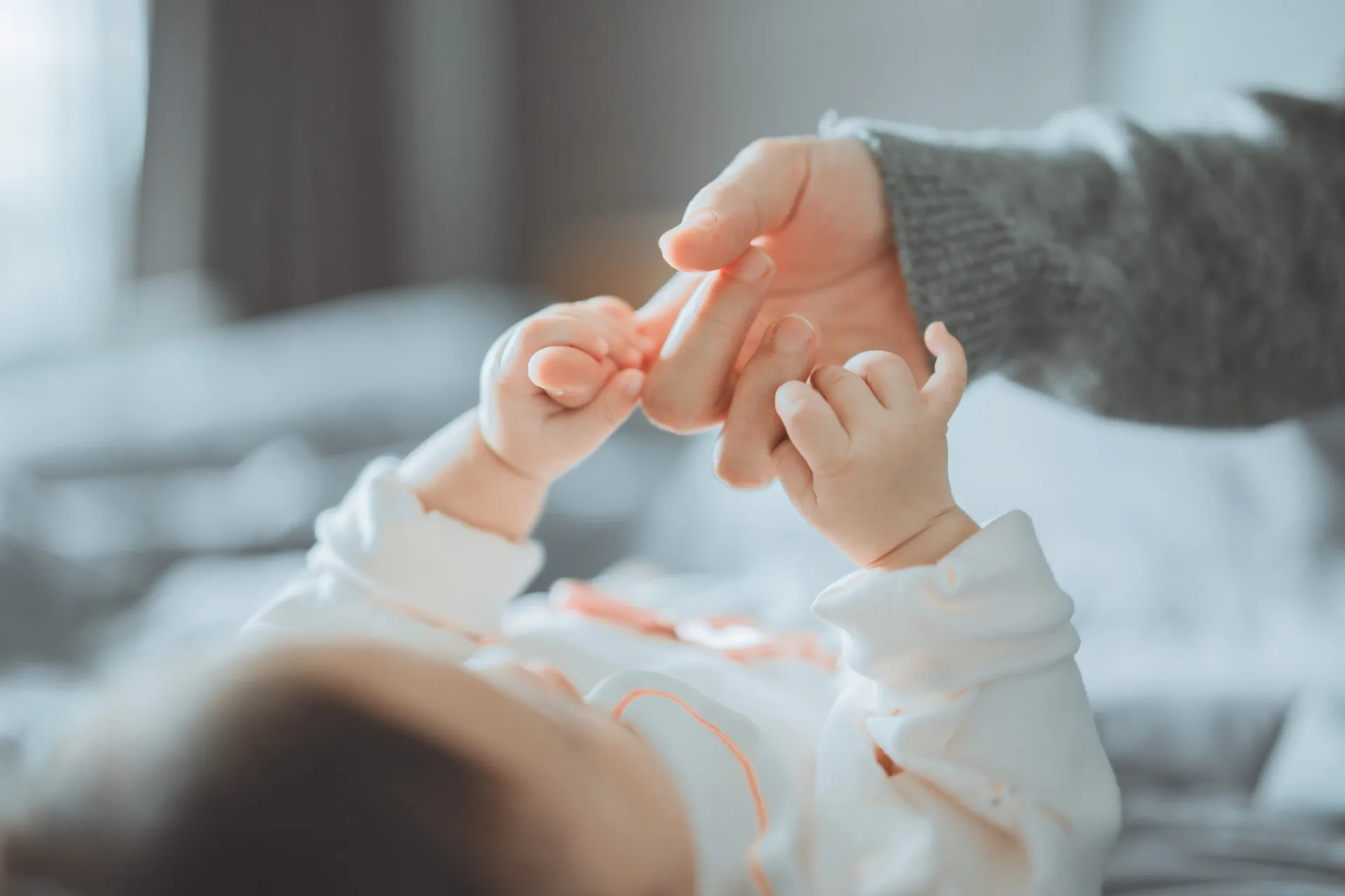 Hände einer erwachsenen Person führen die Hände eines Babys